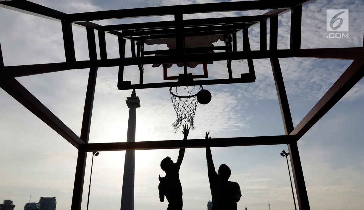 Dua orang warga bermain basket di kawasan Monas, Jakarta, Rabu (13/2). Kawasan Monas menjadi tempat favorit warga Ibu Kota untuk berolahraga. (Bola.com/M Iqbal Ichsan)