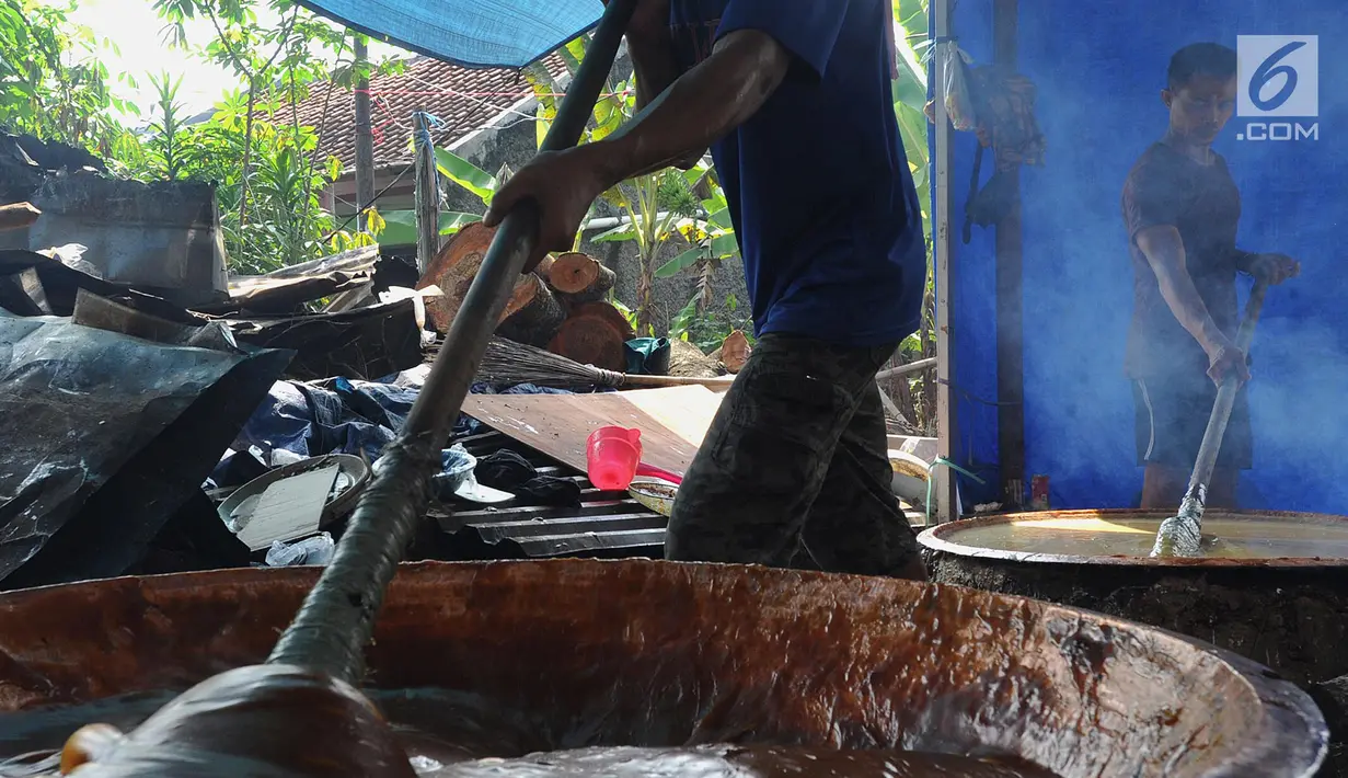 Pekerja mengaduk adonan untuk membuat dodol Betawi di kawasan Studio Alam TVRI, Cilodong, Depok (31/5). Jelang Lebaran, dalam sehari tempat pembuatan ini dapat menghasilkan 400 kilogram dodol. (Merdeka.com/Arie Basuki)