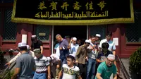 Umat muslim Cina meninggalkan masjid Niujie, Beijing, seusai pelaksanaan salat Idul Fitri, 26 Juni 2017. Masjid Niujie merupakan Masjid bersejarah di Kota Beijing dan mnjadi tempat ibadah masyarakat muslim. (AP Photo/Mark Schiefelbein)