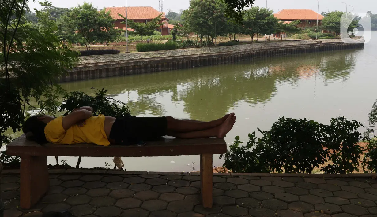 Warga terlihat tidur dipinggir Setu Babakan, Jakarta, Sabtu (14/3/2020). Kawasan Setu Babakan ditutup sementara menyusul instruksi Gubernur DKI Jakarta yang menutup sejumlah lokasi wisata selama 14 hari kedepan sebagau antisipasi penyebaran virus COVID-19. (Liputan6.com/Helmi
Fithriansyah)