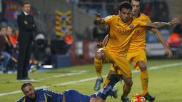 Pemain Barcelona Dani Alves berebut bola dengan pemain Getafe Mehdi Lacen (jatuh) dalam lanjutan La Liga Spanyol di Stadion Coliseum Alfonso Perez,  Getafe, Madrid, Sabtu (31/10/2015) Barcelona menang 2-0. (EPA/Javier Lizon)
