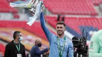 Aymeric Laporte dari Manchester City merayakan dengan trofi di akhir pertandingan final Piala Liga Inggris antara Manchester City dan Tottenham Hotspur di stadion Wembley di London, Minggu, 25 April 2021. Manchester City menang 1-0. (Foto AP / Alastair Gr