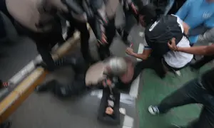 Seorang petugas kepolisian terjatuh saat terjadi aksi saling dorong dengan mahasiswa yang berusaha menerobos barikade aparat dalam demonstrasi memperingati Hari Sumpah Pemuda di kawasan Jalan MH Thamrin, Jakarta Pusat, Rabu (28/10/2026). (KLY/Budy Santoso)