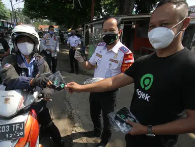 Head of Excellence Regional Operations Public Policy & Government Relations Gojek Muhammad Chairil dan Kadishub Kota Depok Dadang Wihana membagikan masker kepada pengendara dalam rangka Hari Perhubungan Nasional di Kota Depok, Jawa Barat, Jumat (18/8/2020). (Liputan6.com/HO/Ading)