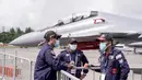 Personel Angkatan Udara Diraja Malaysia mengenakan masker di area static aircraft display selama Singapore Airshow di Singapura, Selasa (11/2/2020). Air show tersebut dibayangi wabah virus korona, yang memaksa puluhan perusahaan dunia absen dalam perhelatan besar itu. (AP/Danial Hakim)