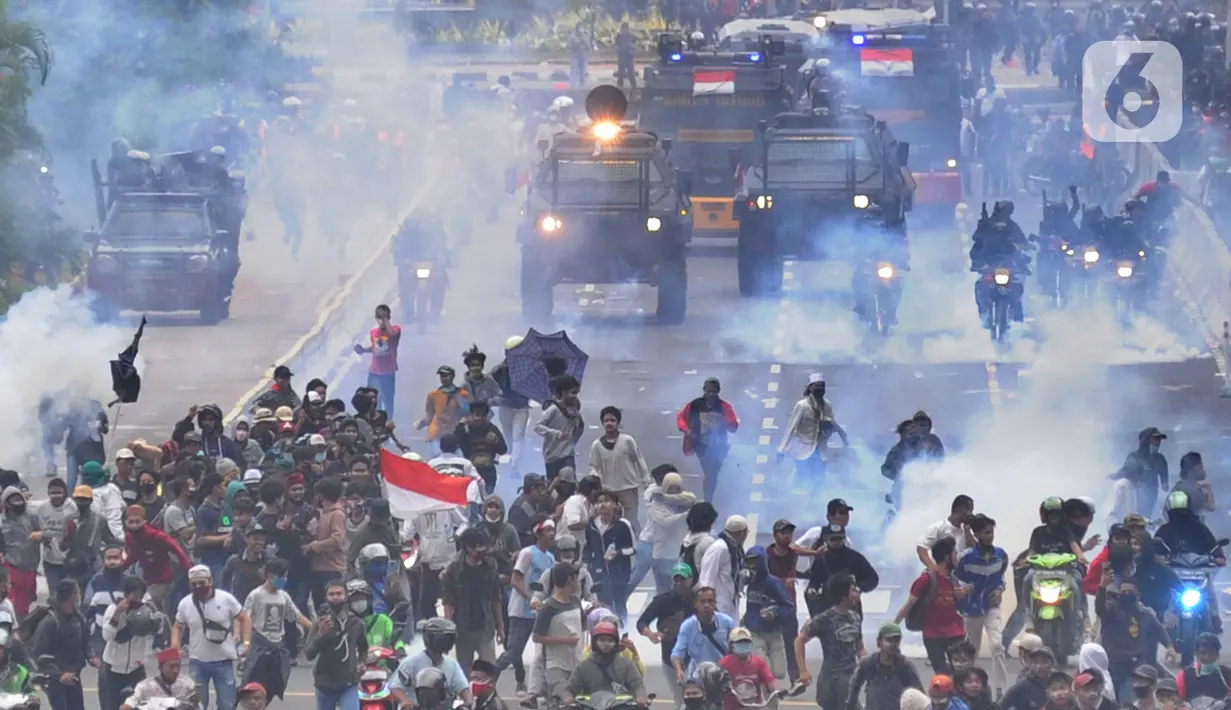 Petugas Brimob Polri menembakkan gas air mata untuk membubarkan massa usai terjadi lemparan batu di Jalan MH Thamrin, Jakarta, Selas (13/10/2020). Massa pengunjuk rasa yang menolak Omnibus Law akhirnya dibubarkan aparat. (merdeka.com/Arie Basuki)