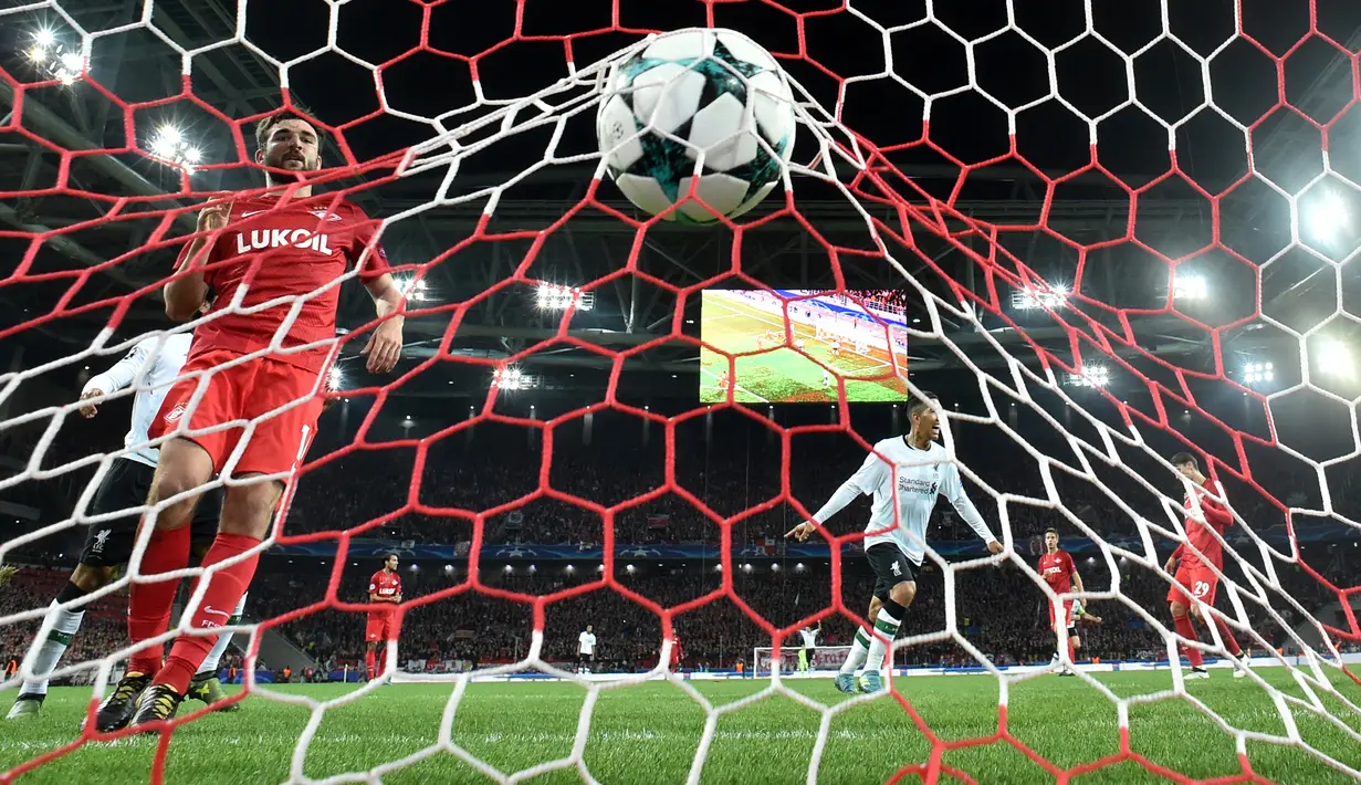Pemain Liverpool, Roberto Firmino merayakan gol Philippe Coutinho ke gawang Spartak Moskow pada matchday 2 Grup E Liga Champions di Otkrytiye Arena, Rabu (27/9). Liverpool harus puas bermain imbang 1-1 di kandang Spartak Moskow. (Kirill KUDRYAVTSEV / AFP)