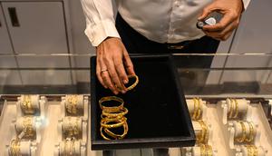 Gambar diambil pada 11 Agustus 2021 menunjukkan seorang manajer toko perhiasan berbicara dengan pelanggan di Mumbai, India. Putus asa mendapatkan uang tunai, banyak keluarga dan usaha kecil menjual perhiasan emas sebagai jaminan untuk mendapatkan pinjaman jangka pendek. (Punit PARANJPE/AFP)