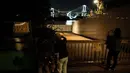 Warga melihat simbol Paralimpiade yang menyala dengan latar belakang Jembatan Pelangi dan Menara Tokyo di tepi Pantai Odaiba, Tokyo, Jepang, 23 Agustus 2021. Paralimpiade Tokyo 2020 mulai 24 Agustus 2021 sampai 5 September 2021. (Charly TRIBALLEAU/AFP)