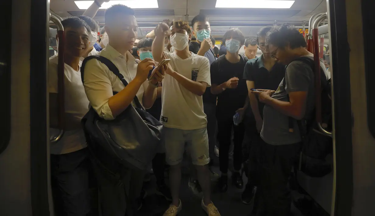 Para pengunjuk rasa mengenakan masker berada di kereta bawah tanah di Hong Kong, Selasa (30/7/2019). Para pengunjuk rasa telah mengganggu layanan kereta bawah tanah pada pagi hari perjalanan dengan menghalangi pintu-pintu masuk kereta dan mencegah mereka meninggalkan stasiun. (AP Photo/Vincent Yu)