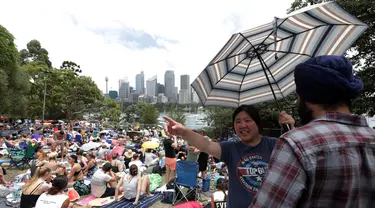 Ribuan warga duduk di lapangan untuk menonton kembang api jelang pergantian Tahun Baru di Sydney, Australia, (31/12/2016). Mereka sudah berada di taman sejak pukul 06.30 page waktu setempat. (REUTERS/Jason Reed)