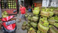 Pekerja menata tabung gas elpiji 3 kg ke atas sepeda motor untuk didistribusikan di kawasan Jakarta, Rabu (4/1/2023). Tahun 2023, pembelian elpiji 3 kg akan diperketat dengan menggunakan KTP. (Liputan6.com/Angga Yuniar)