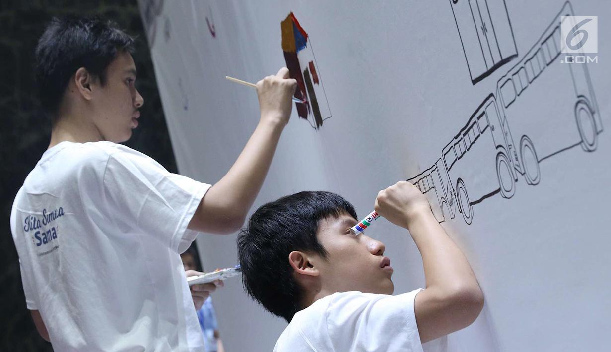 Penyandang disabilitas tampak serius saat melukis mural di kanvas sepanjang 20 meter di Balai Kota DKI Jakarta, Kamis (11/10). Kegiatan tersebut diadakan sebagai sarana untuk para penyandang disabilitas berkarya. (Liputan6.com/Immanuel Antonius)