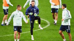 Kiper Spanyol, David de Gea (tengah) melakukan pemanasan selama sesi latihant tim di Stadion Wanda Metropolitano di Madrid (17/11/2019). Spanyol akan bertanding melawan Rumania pada Grup F Kualifikasi Piala Eropa 2020. (AFP Photo/Gabriel Bouys)