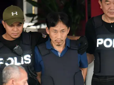 WN Korut Ri Jong Chol dikawal dua anggota polisi meninggalkan markas Polisi Sepang, Malaysia, Jumat (3/3). Kurangnya bukti terkait pembunuhan terhadap Kim Jong-nam, Malaysia resmi membebaskan Ri Jong Chol dari tahanan. (Muneyoshi Someya/Kyodo News via AP)