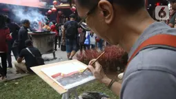 Anggota komunitas pelukis cat air Indonesia melukis suasana perayaan Imlek di Vihara Dharma Bhakti, Petak Sembilan, Jakarta Barat, Sabtu (25/1/2020). Kegiatan melukis tersebut untuk memeriahkan perayaaan Tahun Baru Imlek 2571. (Liputan6.com/Angga Yuniar)