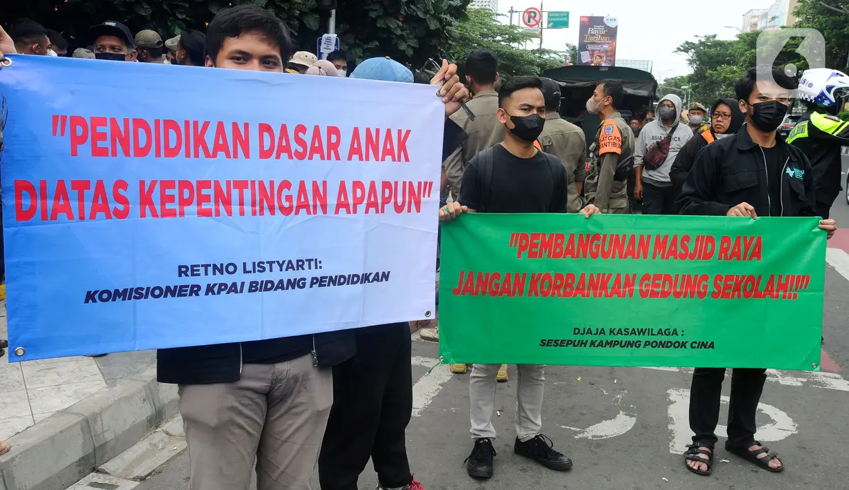 Relawan membentang poster saat pasukan Satpol PP yang hendak mengosongkan bangunan SDN Pondok Cina 1, Depok, Jawa Barat, Minggu (11/12/2022). Satpol PP Pemkot Depok melakukan pemindahan aset dan menggusur bangunan SDN Pondok Cina 1 pada Minggu pagi. (merdeka.com/Arie Basuki)