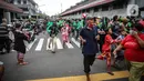 Warga dan pengemudi ojek online mengantre nasi kotak serta masker dari TNI di Markas Komando Gabungan Wilayah I, Jakarta, Selasa (21/4/2020). Dalam rangka Hari Kartini, TNI membagikan makanan dan masker kepada masyarakat. (Liputan6.com/Faizal Fanani)