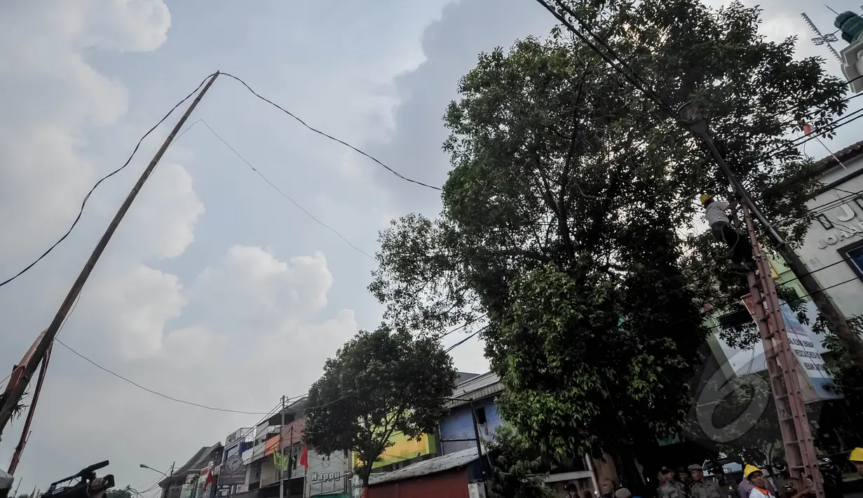 Petugas PLN dibantu Satpol PP menertibkan sambungan listrik liar di Johar Baru, Jakarta, Rabu (25/3/2015). Kegiatan itu untuk mengurangi saluran listrik ilegal dan mencegah kebakaran.   (Liputan6.com/Faizal Fanani)