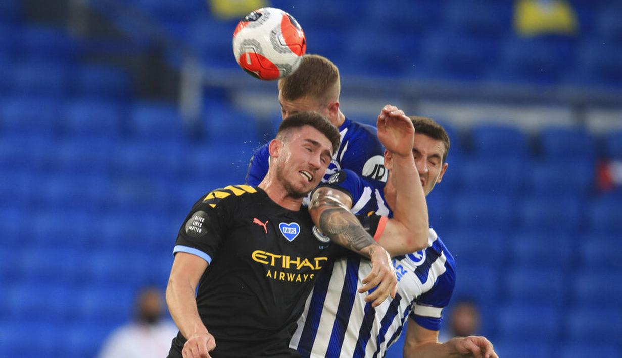 Pemain Manchester City, Aymeric Laporte, berebut bola dengan pemain Brighton and Hove Albion, Lewis Dunk, pada laga Premier League di Stadion Falmer, Sabtu (11/7/2020). Manchester City menang 5-0. (Adam Davy/Pool via AP)