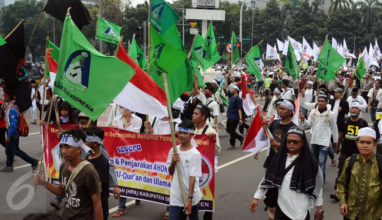 Ratusan massa aksi damai berkumpul di sekitar Bundaran Patung Arjuna Wijaya, Jakarta, Jumat (4/11). Massa berkumpul untuk melakukan aksi di depan Istana Negara menuntut penegakan hukum kasus dugaan penistaan agama. (Liputan6.com/Helmi Fithriansyah)