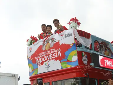 Tontowi Ahmad, Liliyana Natsir, Eko Yuli dan Sri Wahyuni  dsaat menaiki bus Bandros di Terminal 3, Bandara Soekarno-Hatta, Jakarta, Selasa (23/8/2016). (Bola.com/Nicklas Hanoatubun)