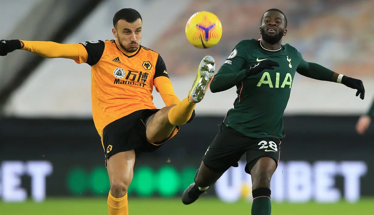 Gelandang Wolverhampton Wanderers, Roman Saiss (kiri), berebut bola dengan gelandang Tottenham Hotspur, Tanguy Ndombele, dalam laga lanjutan Liga Inggris 2020/21 pekan ke-15 di Molineux Stadium, Minggu (27/12/2020). Wolherhampton bermain imbang 1-1 dengan Spurs. (AFP/Lindsey Parnaby/Pool)