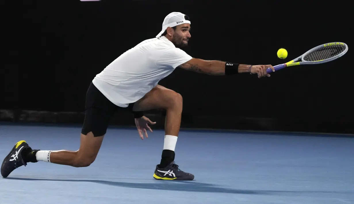 Matteo Berrettini dari Italia melakukan pukulan backhand saat menghadapi Rafael Nadal dari Spanyol dalam pertandingan semifinal kejuaraan tenis Australia Terbuka di Melbourne, Australia, Jumat (28/1/2022). (AP Photo/Simon Baker)
