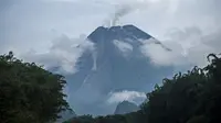 Gunung Merapi saat memuntahkan bebatuan dan gas di Yogyakarta, Kamis (21/1/2021). Pada periode pengamatan Jumat (22/1) pukul 18.00-24.00 WIB, Gunung Merapi tercatat 12 kali meluncurkan guguran lava pijar dengan jarak luncur maksimum 300-600 meter ke arah barat daya. (AFP/Agung Supriyanto)