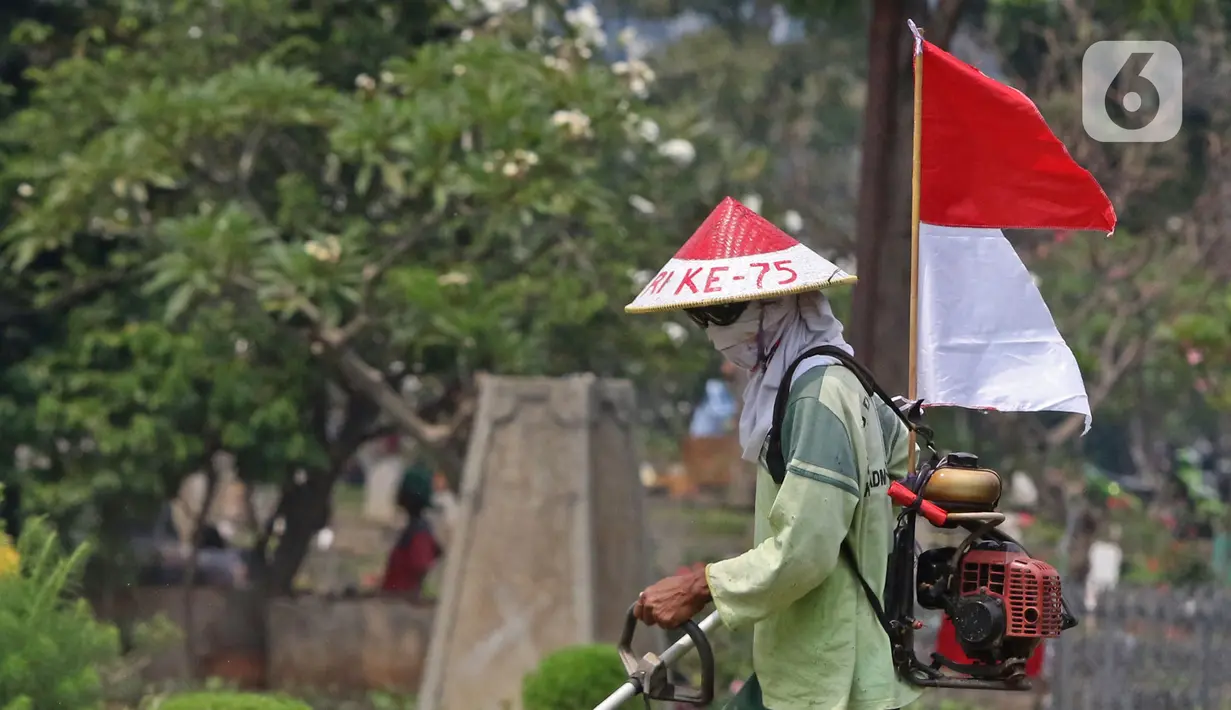 Petugas Pertamanan dan Kehutanan Kota Jakarta Pusat mengenakan atribut kemerdekaan saat memotong rumput di TPU Karet Bivak, Jakarta, Minggu (16/8/2020). Para petugas bekerja dengan mengenakan atribut kemerdekaan dalam rangka menyambut HUT ke-75 RI. (Liputan6.com/Herman Zakharia)