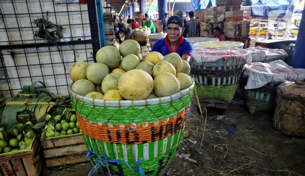 Pedagang mendorong gerobak berisi buah segar yang akan di jual di pasar Kramat Jati, Jakarta, Kamis (13/3/2025). (Liputan6.com/Angga Yuniar)