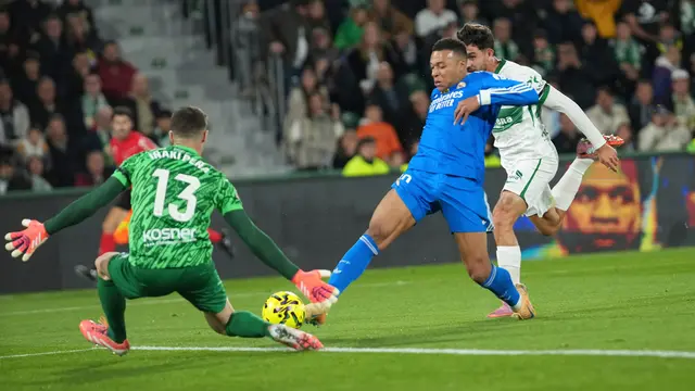 Penyerang Real Madrid, Kylian Mbappe (tengah), berupaya menaklukkan kiper Elche, Inaki Pena