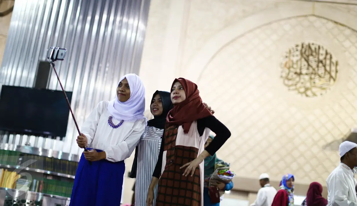 Sejumlah jemaah wanita melakukan wefie usai salat Idul Fitri di Masjid Istiqlal, Jakarta, Rabu (6/7). Selain menjalankan salat Idul Fitri, beberapa aktivitas mereka lakukan baik seusai ataupun sebelum salat. (Liputan6.com/Faizal Fanani)
