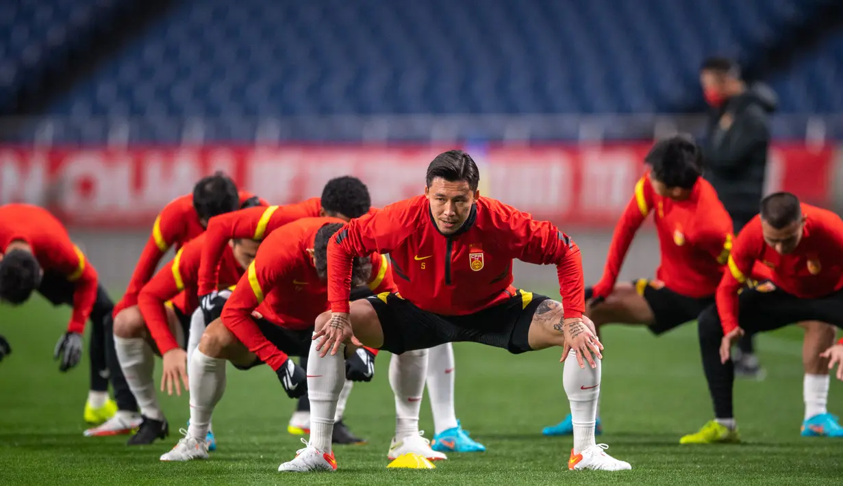 Para pemain China melakukan pemanasan saat mengikuti sesi latihan di Stadion Saitama, Jepang, Rabu (26/1/2022). China akan menghadapi Jepang pada Kualifikasi Piala Dunia 2022 Grup B Zona AFC. (AFP/Philip Fong)