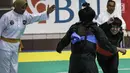 Pesilat Nirmalasari Oktaviani (kanan) beradu jurus dengan pesilat Laos Olathai Sounthavong di semifinal 50-55 kg putri cabang Pencak Silat 18th Asian Games Invitation Tournament, Jakarta, Senin (12/2). Indonesia menang 5-0. (Liputan6.com/Faizal Fanani)