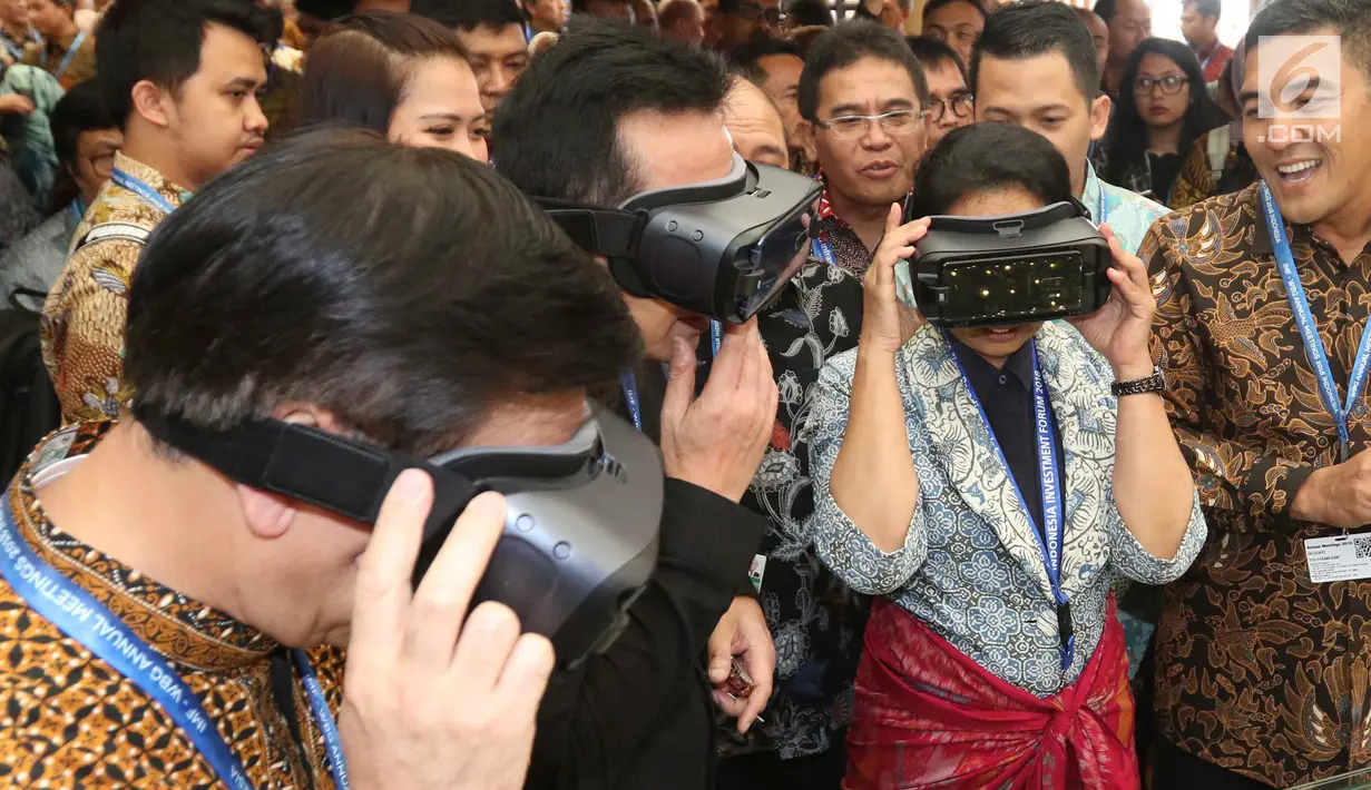 Menteri BUMN Rini Soemarno dan Kepala Bekraf Triawan Munaf mencoba sebuah alat di salah satu stand milik perusahaan BUMN selama ajang Pertemuan Tahunan IMF-World Bank Group 2018 di Nusa Dua Bali, Selasa (9/10). (Liputan6.com/Angga Yuniar)