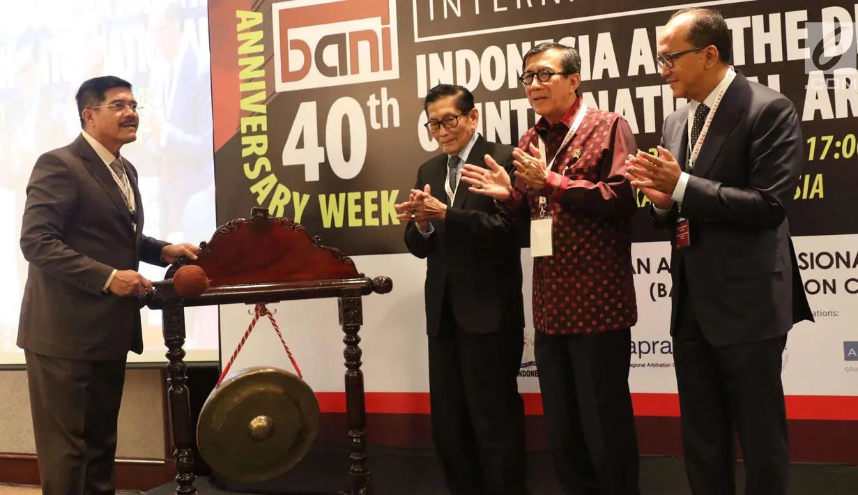 Ketua Mahkamah Agung RI Hatta Ali (kiri) bersiap memukul gong saat pembukaan seminar bertajuk "Indonesia and The Development of International Arbitration" di Jakarta, Selasa (28/11). (Liputan6.com/Angga Yuniar)
