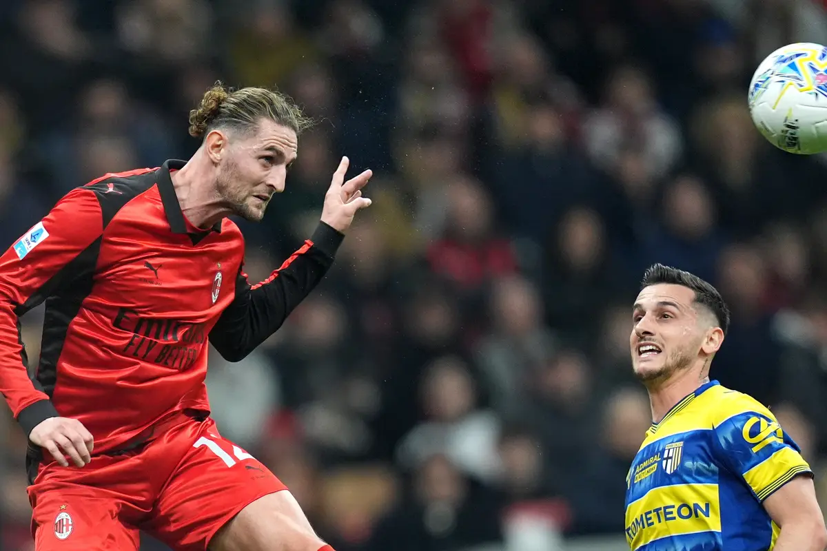 Pemain AC Milan Adrien Rabiot (kiri) berebut bola dengan pemain Parma Emanuele Valeri