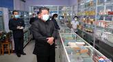 Pemimpin Korea Utara Kim Jong Un mengenakan masker memeriksa apotek di tengah wabah Covid-19 di Pyongyang, Korea Utara pada 15 Mei 2022. Sejak negara itu pertama terkena wabah COVID-19, Apotek Korea Utara sekarang buka 24 jam sehari. (STR/KCNA VIA KNS/AFP)