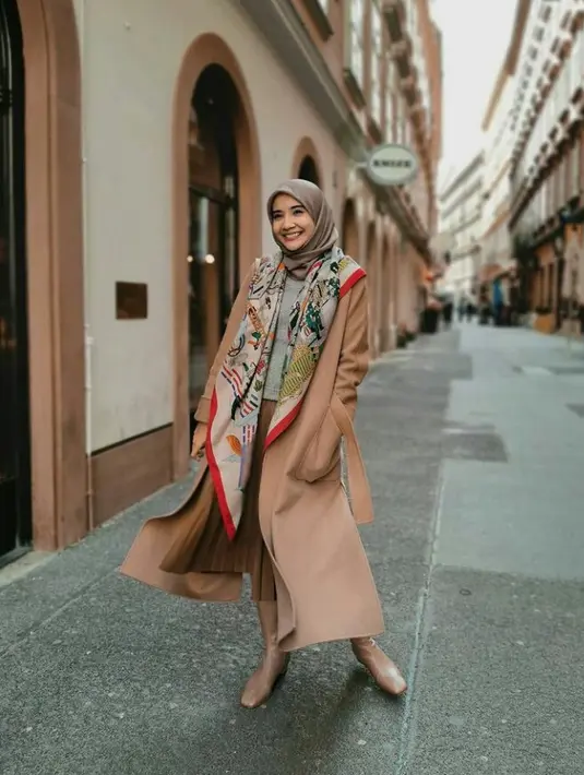 Padu padan rain coat dan plisket skirt juga tak kalah menarik. Tambahkan scarf motif agar membuat penampilanmu makin stand out. (FOTO: Instagram.com/Zaskiasungar15).