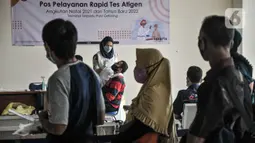 Petugas kesehatan dari Dishub melayani rapid tes antigen pada calon penumpang bus AKAP sebelum keberangkatan di Terminal Terpadu Pulogebang, Jakarta Timur, Selasa (21/12/2021). Tes antigen menjadi syarat wajib penumpang bus AKAP selama libur Natal dan Tahun Baru. (merdeka.com/Iqbal S. Nugroho)