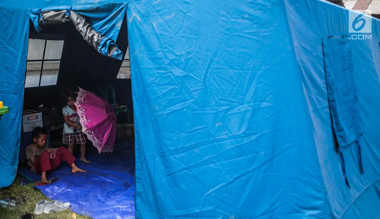 Anak-anak korban rumah ambles beraktivitas di tenda pengungsian di Lodan Raya, Pademangan, Jakarta Utara, Kamis (22/11). Pemerintah DKI Jakarta akan membangun rumah bagi warga yang terdampak pengerukan Anak Kali Ciliwung. (Liputan6.com/Faizal Fanani)