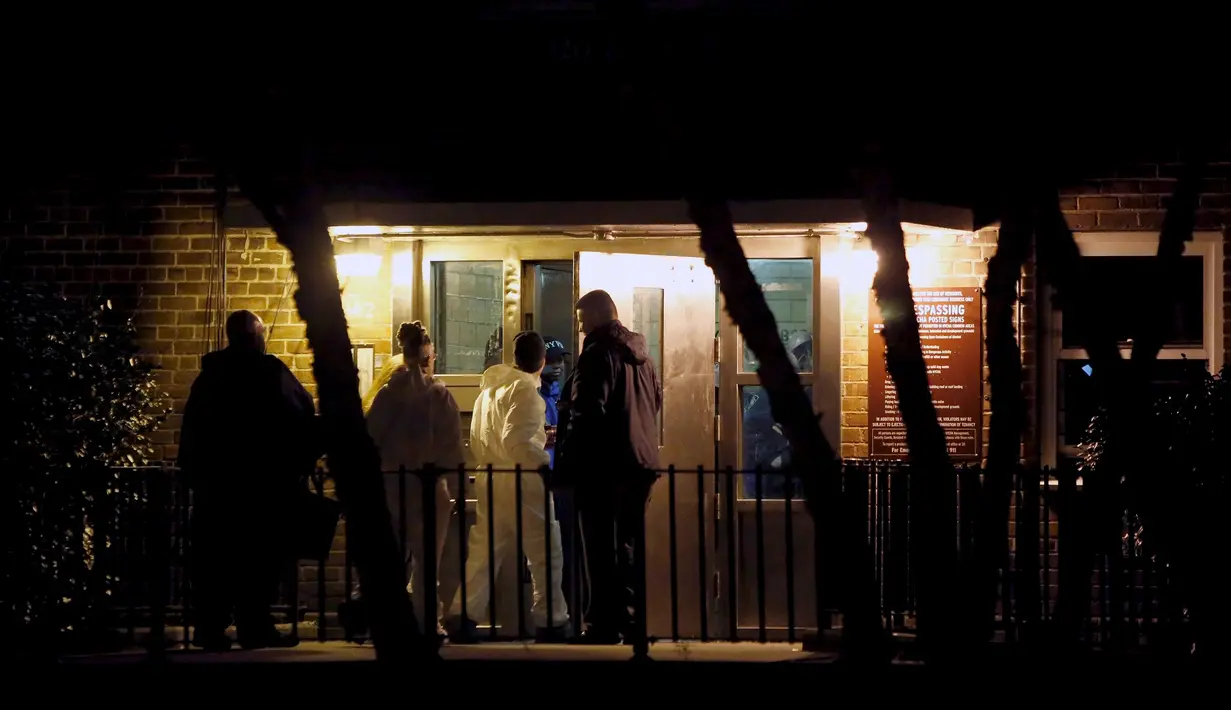 Petugas penyelidik memasuki sebuah gedung tempat dua polisi New York ditembak di Bronx, Kamis (4/2). Dua orang polisi ditembak saat tengah melakukan patroli malam di komplek perumahan di Bronx. (REUTERS/Andrew Kelly)