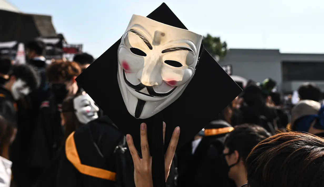 Mahasiswa mengenakan topeng Guy Fawkes selama aksi protes pada upacara kelulusan mereka di Chinese University of Hong Kong, Hong Kong, Kamis (7/11/2019). Sekitar seribu mahasiswa mengabaikan larangan mengenakan topeng yang dikeluarkan pemerintah pada Oktober 2019. (Philip FONG / AFP)