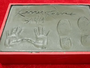 Cetakan tangan dan kaki aktor Keanu Reeves dalam upacara pembuatan cetakan tangan dan kaki di TCL Chinese Theatre, Los Angeles, Selasa (14/5/2019). Aktor 54 tahun itu mendapat penghargaan membuat cetakan tangan dan kaki untuk merayakan keberhasilan karirnya dalam film. (Willy Sanjuan/Invision/AP)