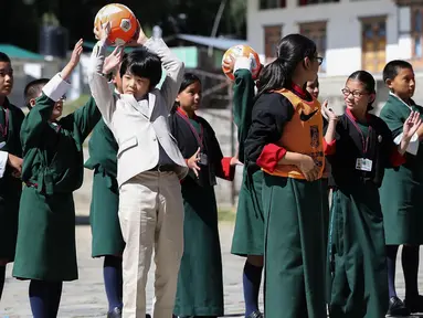 Pangeran Hisahito (tengah) berusia 12 tahun dari Jepang mengoper bola saat bermain bersama siswa setempat saat mengunjungi sebuah sekolah di Thimpu, Bhutan, Selasa (20/8/2019). (AFP Photo/Japan Out/Jiji Press)