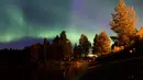 Pancaran cahaya aurora borealis menghiasi Desa Erikslund di Vasternorrland County, Swedia (23/8). Fenomena alam yang indah ini terjadi pada bulan Maret-April dan September-Oktober. (AFP PHOTO/ JONATHAN NACKSTRAND)