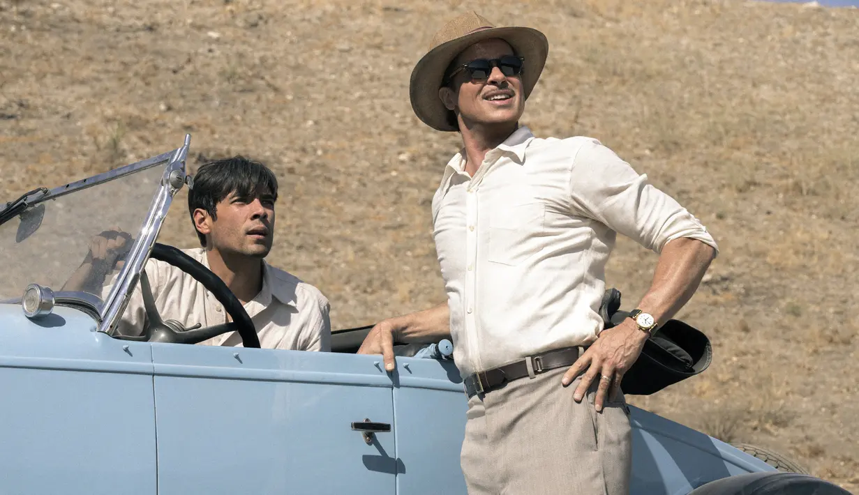 Diego Calva (kiri) dan Brad Pitt dalam sebuah adegan film ‘Babylon’. Bayangan publik tentang Hollywood era 1920-an selama ini dikenal penuh glamor dan artis-artis anggun akan terpatahkan dengan penampilan Nellie LaRoy (Margot Robbie) yang mulai kehilangan kendali dan melakukan hal-hal yang tidak waras, seperti menantang para hadirin untuk menyaksikannya bertarung dengan ular. (Scott Garfield/Paramount via AP)