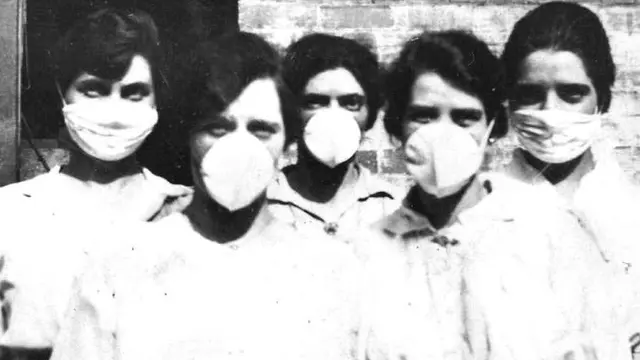 Masker banyak digunakan selama pandemi flu Spanyol di tahun 1918, dan seratus tahun kemudian juga kembali digunakan. (State Library of Queensland)