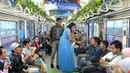 Sebuah rangkaian KRL Commuter Line didekorasi bertema film Cinderella. Tokoh dongeng Cinderella memberikan bunga pada penumpang Commuter Line Jakarta - Bogor, Jakarta, Sabtu (14/02/2015). (Liputan6.com/Andrian M Tunay)